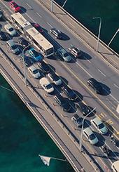 Photo du pont du Mont-Blanc avec un bouchon de voitures et un bus qui les dépasse